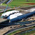 Aerial view of a motorway interchange under construction with white EPS Geofoam blocks stacked inside a bridge approach embankment