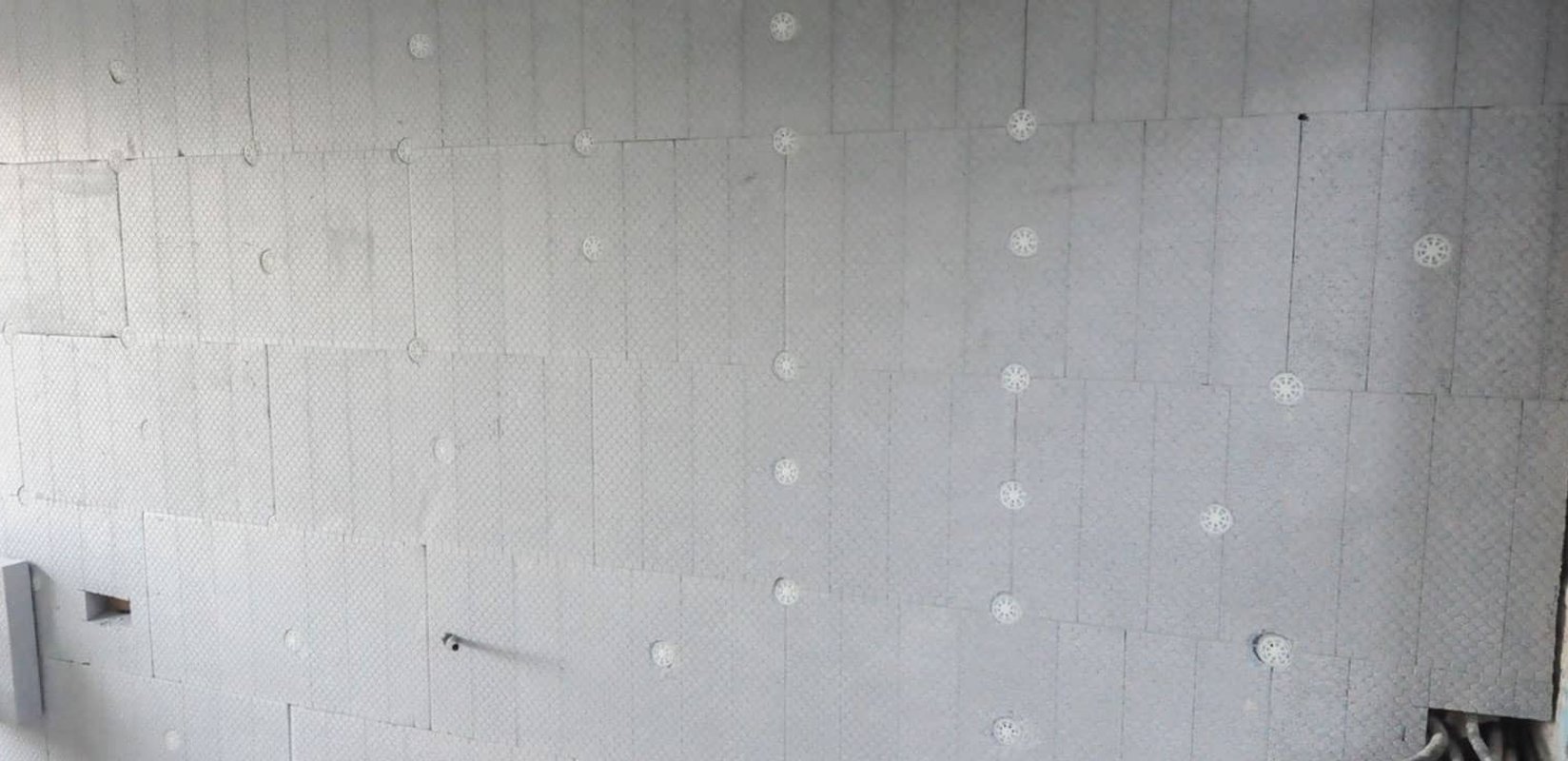 Stacks of white EPS foam insulation boards cut to size and labelled for staged delivery at a New Zealand construction site in spring