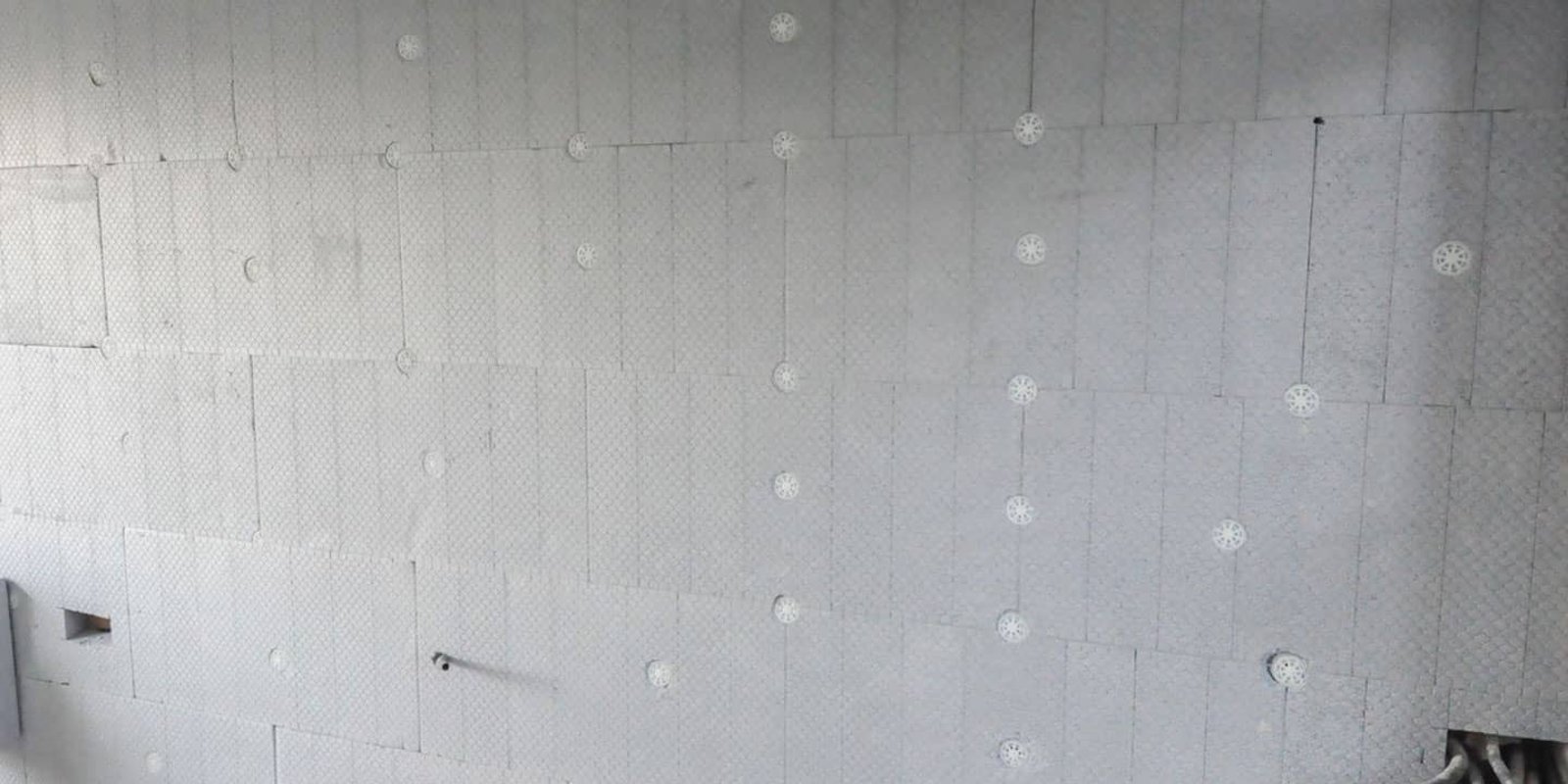 Stacks of white EPS foam insulation boards cut to size and labelled for staged delivery at a New Zealand construction site in spring